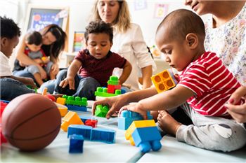 a group of children and adults at a play group
