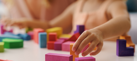 image of a small child playing with brightly coloured wooden blocks