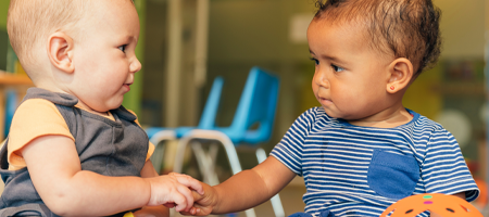 image of two babies playing together